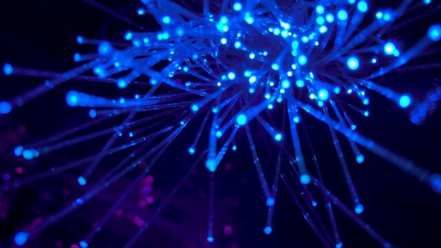 青く光るファイバーオプティックケーブル。高速インターネット回線のイメージ