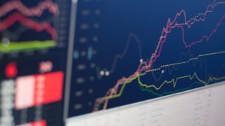 複数の色分けされた折れ線グラフが上昇トレンドを示す株価モニター画面